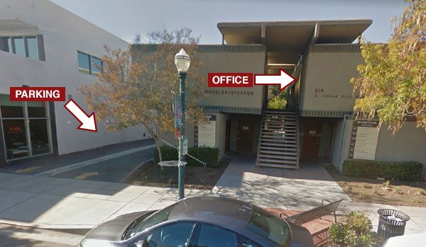 Street view showing the office entrance upstairs and parking access to the left