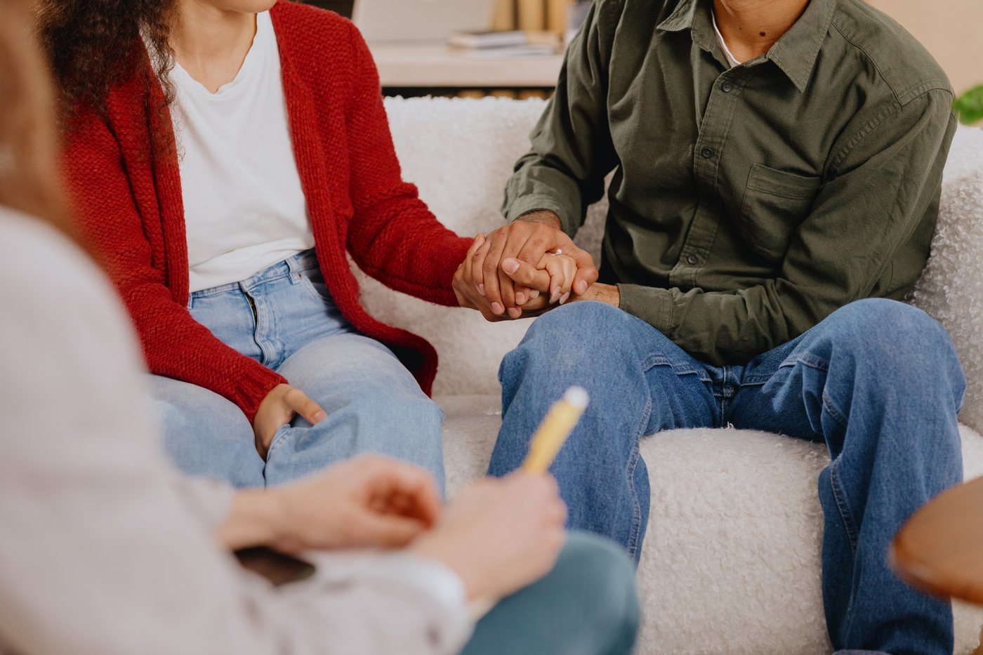 A couple holding hands during a therapy session
