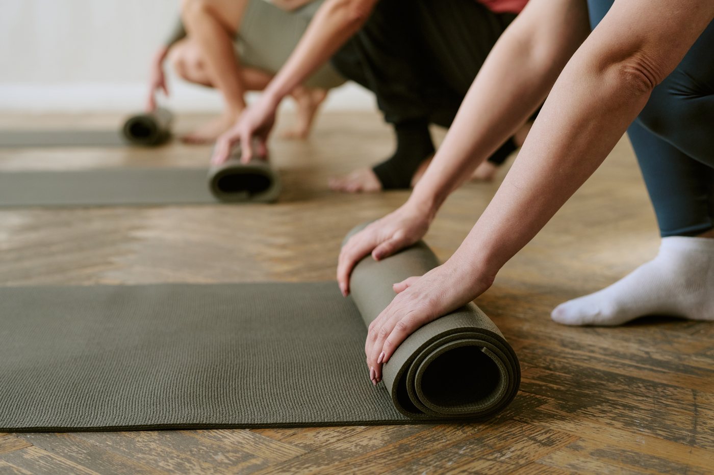 People rolling out yoga mats for practice